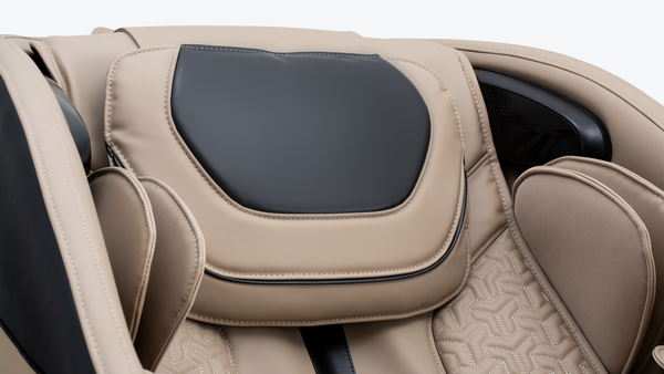 Beige massage chair with a black headrest and quilted upholstery.