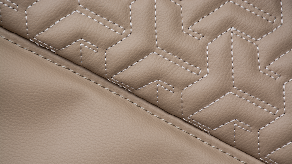 Close-up of beige quilted leather with geometric stitching.